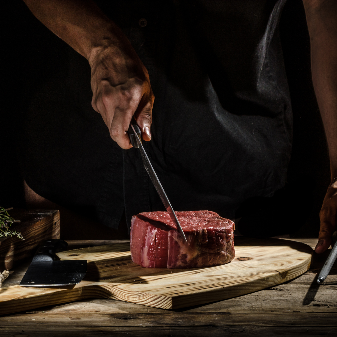 Fillet steak with a carving knife in it ready for the outdoor kitchen