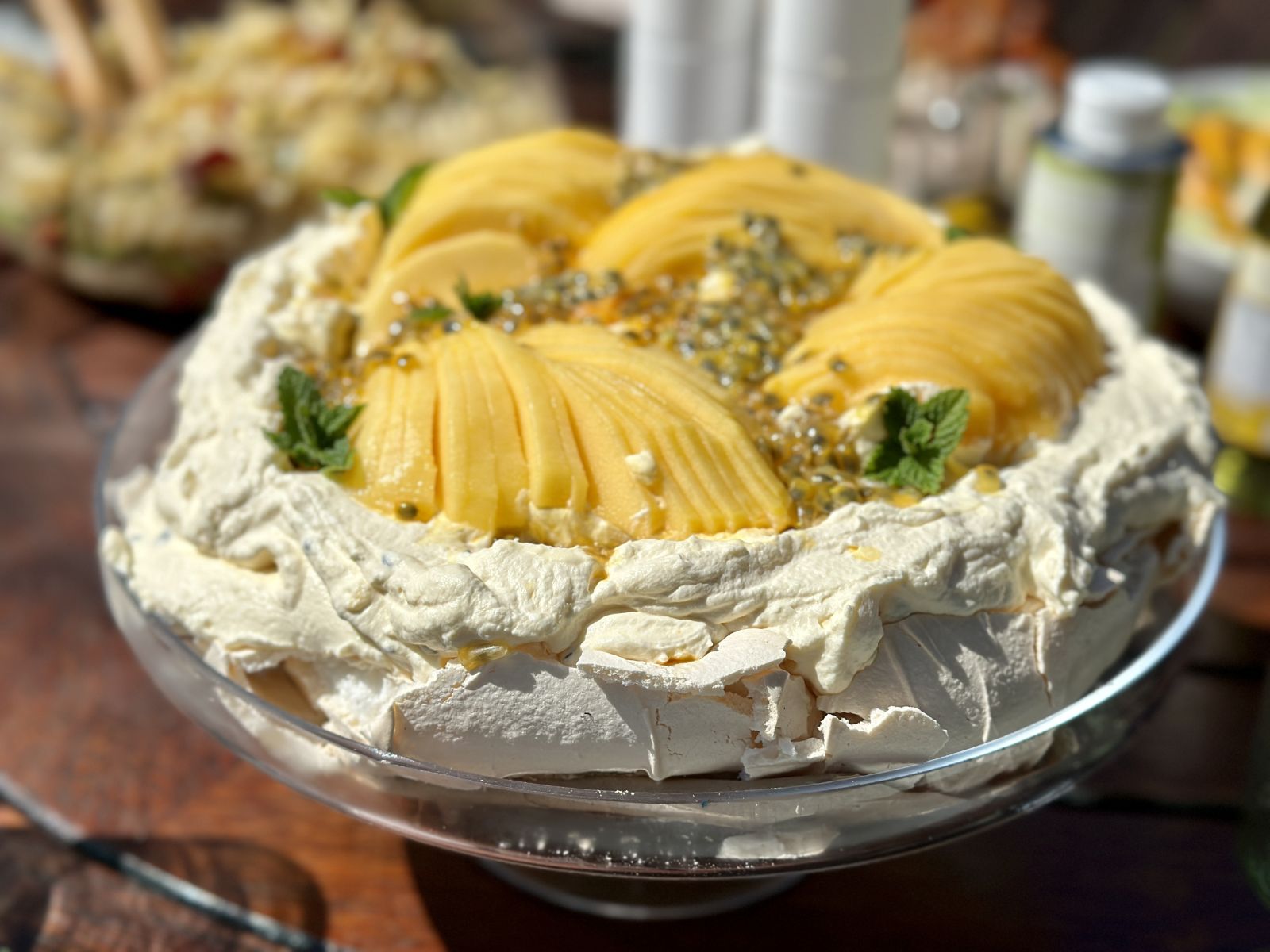 A pavlova topped with mangoes and passionfruit