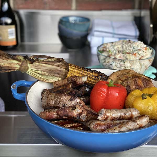 Barbecued mixed grill with sausages, capsicums, corn and lamb cutlets on an alfresco bbq kitchen