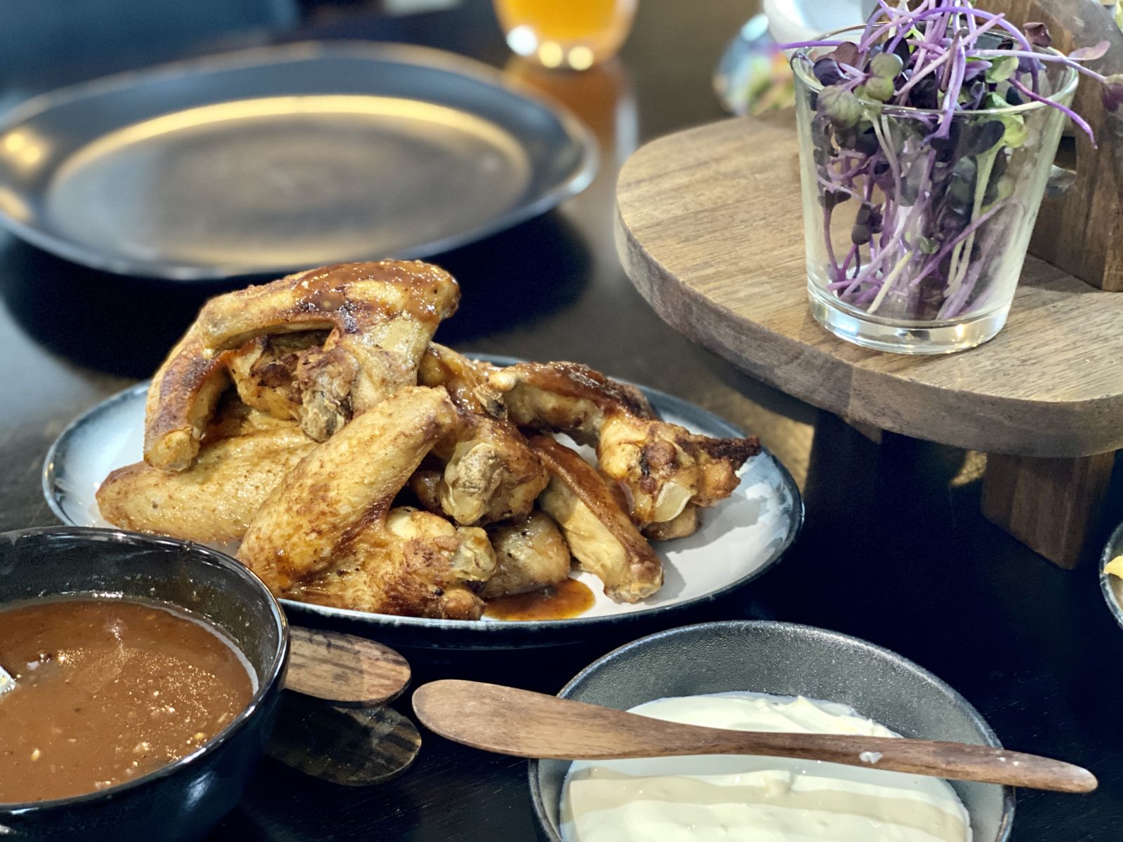 Chicken wings with buffalo sauce, sour cream and micro herbs