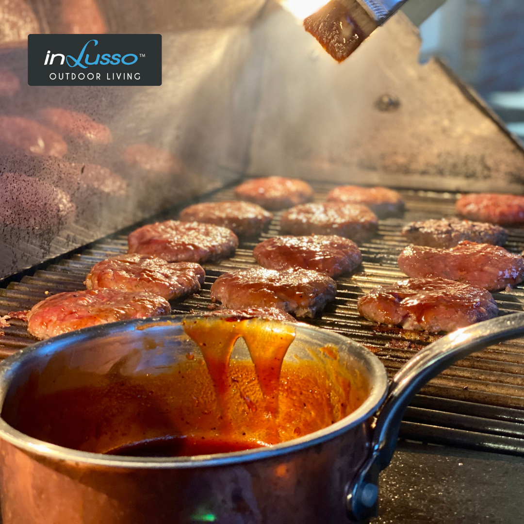 Burger patties on a BBQ with whisky glaze