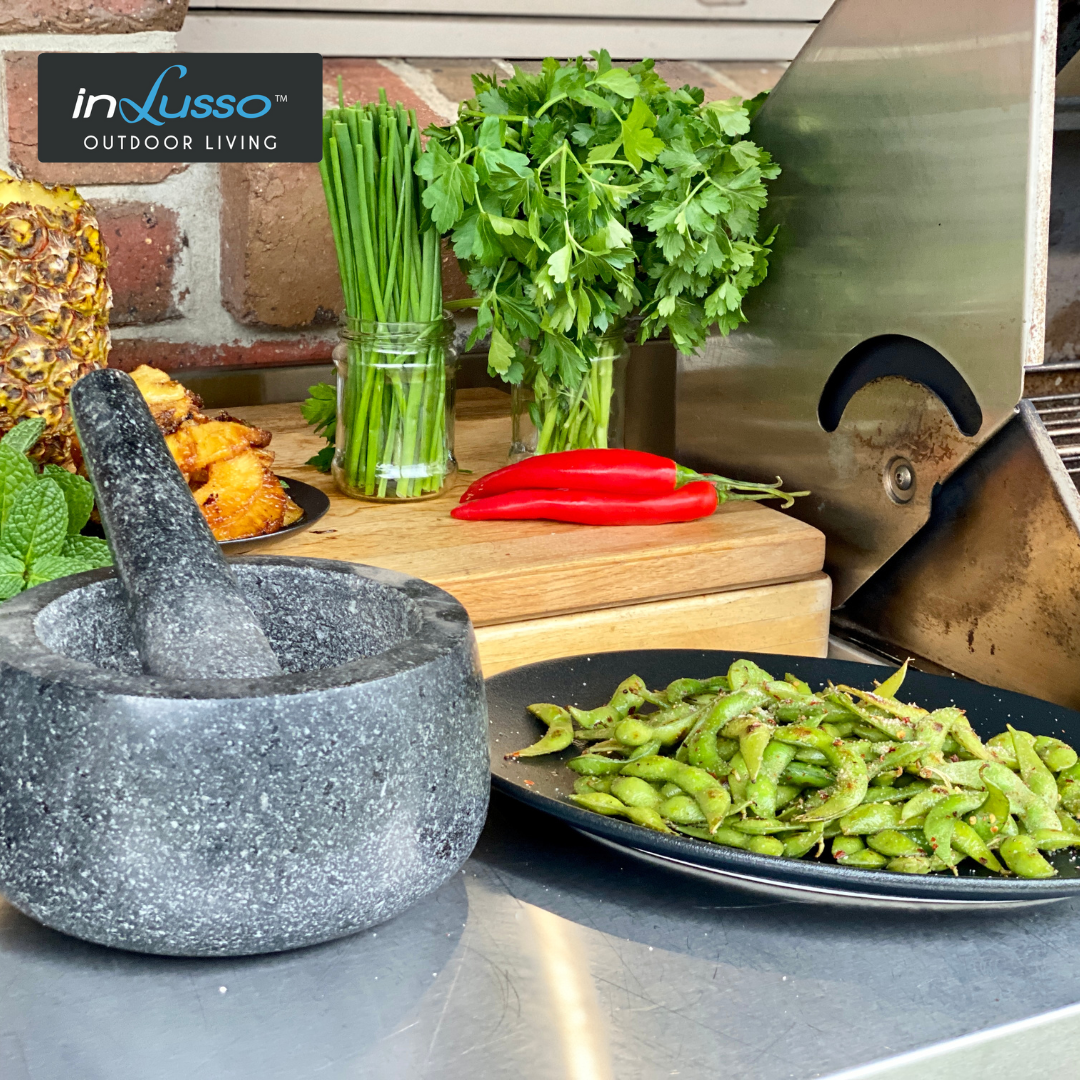 BBQ edamame on an outdoor BBQ kitchen with herbs and chilli salt