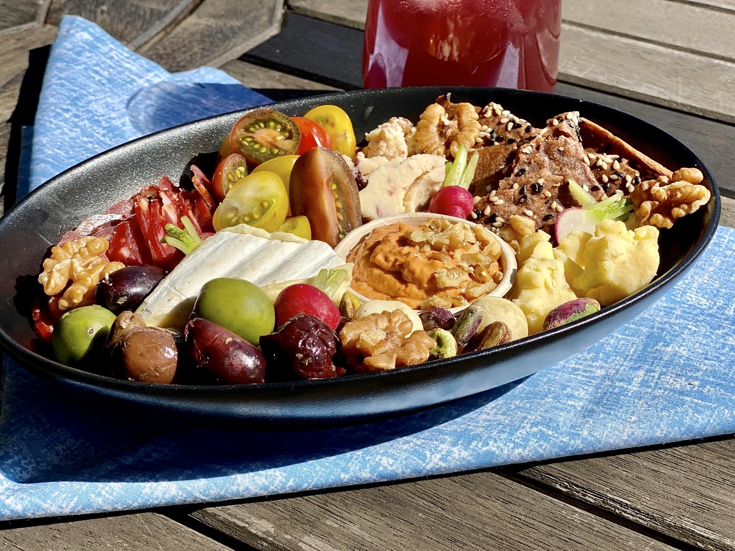 cheese, olives, dip and tomatoes on a plate