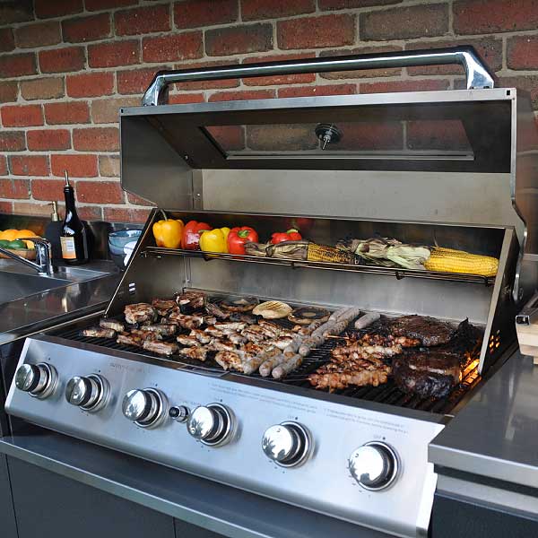 An outdoor alfresco BBQ kitchen with 6-burner hooded gas barbeque and stainless steel sink