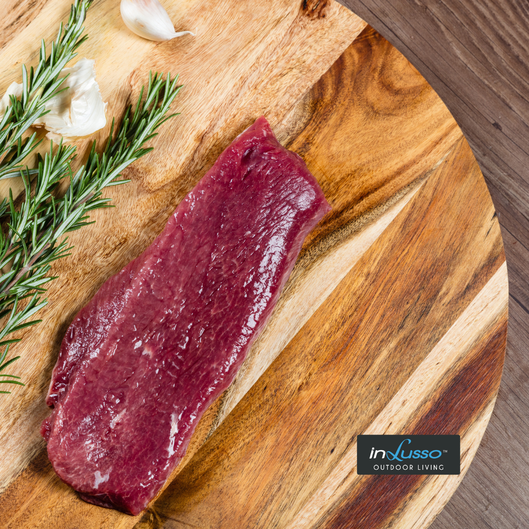 A piece of lamb backstop on a board with Rosemary