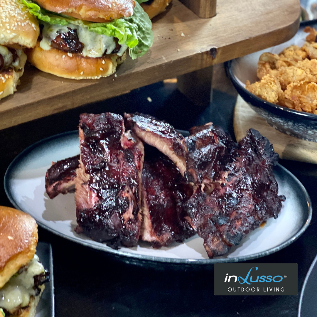 Spicy BBQ ribs on a table full of food 