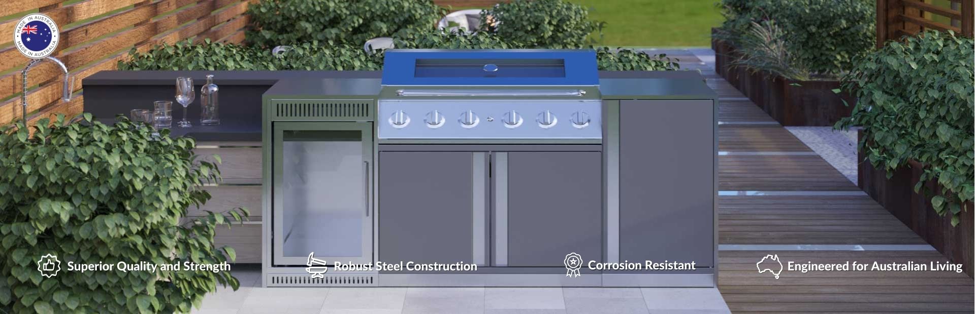 An outdoor kitchen with 6-burner BBQ with hood, grey cabinets and draws, bar fridge in an alfresco area.